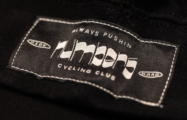 Missing Link Hoodie woven label reading Always Pushin Number5 Cycling Club on black fabric