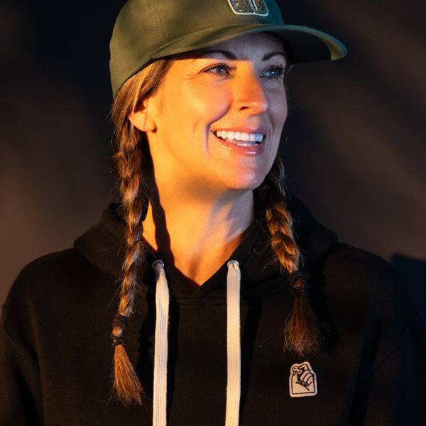 Rider in the Missing Link Hoodie and an olive Number5 patch hat at golden hour
