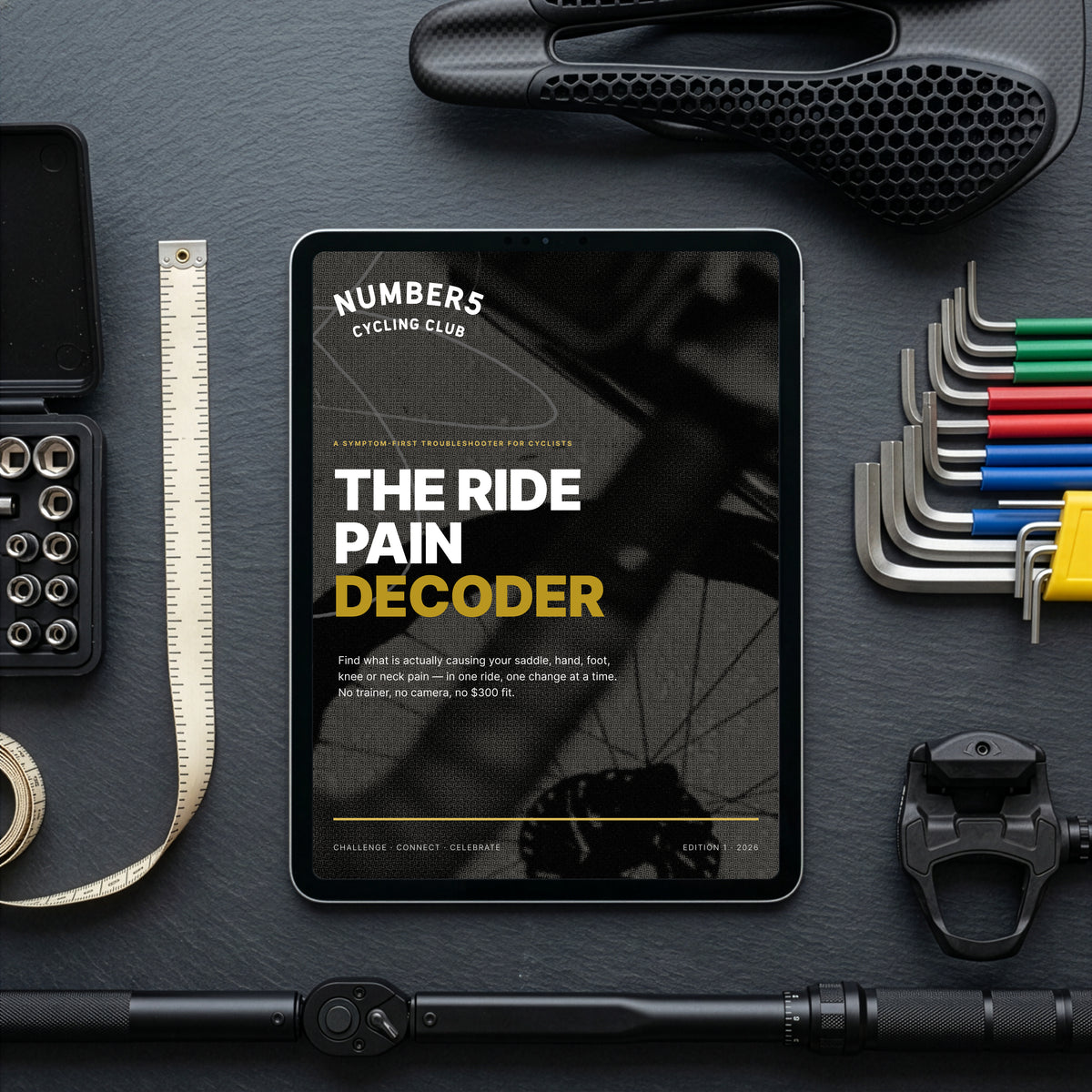 The Ride Pain Decoder guide on a tablet, surrounded by a saddle, hex keys, pedals and a tape measure